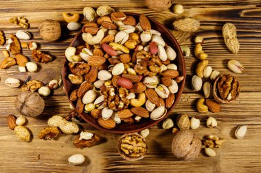 Tahta masada karışık fındık. Ceviz, fıstık, badem, fıstık, fındık, seramik kasede fındık. Sağlıklı beslenme konsepti. Üst görünüm