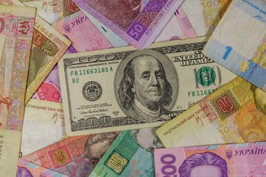 Ukrayna Hryvnia banknotlarının arka planında 100 dolarlık banknot