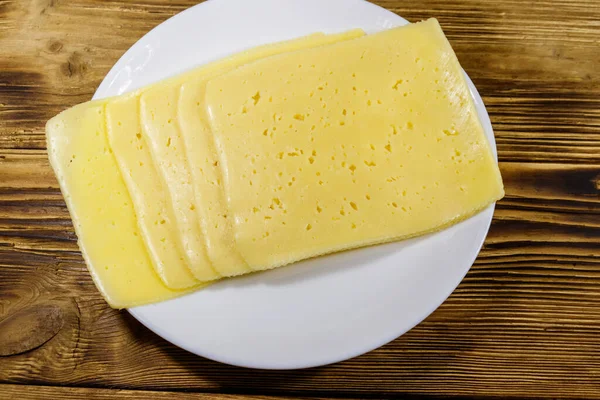 Rebanadas Queso Plato Sobre Una Mesa Madera Vista Superior —  Fotos de Stock