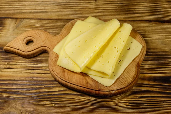 Rebanadas Queso Sobre Tabla Cortar Sobre Mesa Madera —  Fotos de Stock