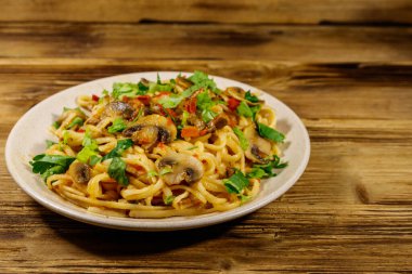 Mantarlı makarna ve ahşap masada domates sosu.