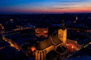 Ukrayna, Lviv 'deki Aydınlatılmış Latin Katedrali ve Rynok Meydanı' nın gece görüşü. Lviv belediye binasından görüntü