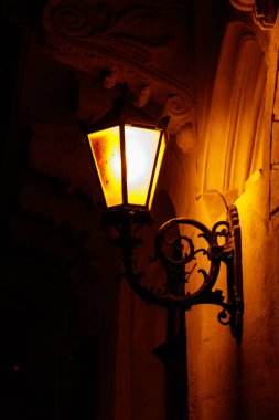 Geceleri evin duvarında ışıklı klasik sokak feneri.