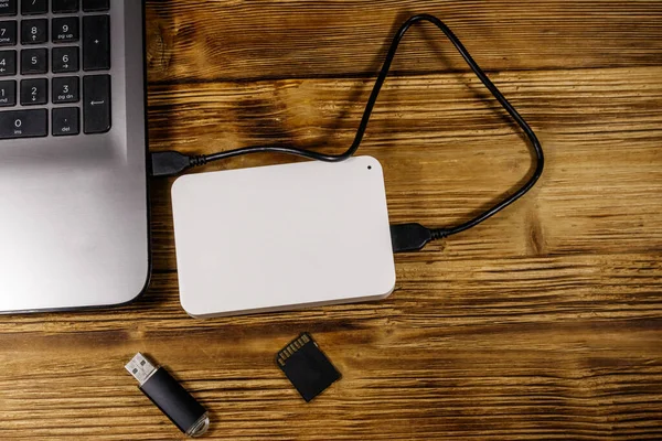 Harici HDD dizüstü bilgisayara, hafıza kartına ve USB flash diske bağlı. Üst Manzara. Veri depolama kavramı