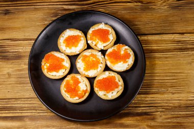 Kırmızı havyarlı turta ve ahşap bir masada yumuşak peynir. Üst görünüm