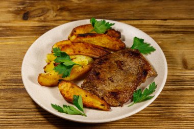 Tahta masada patates dilimli kızarmış biftek.