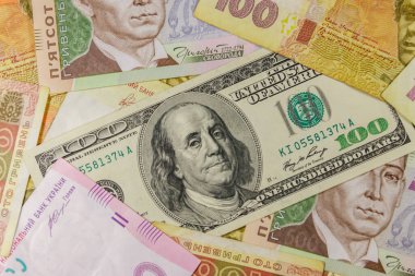 Farklı Ukrayna Hryvnia banknotlarının arka planında 100 dolarlık banknot