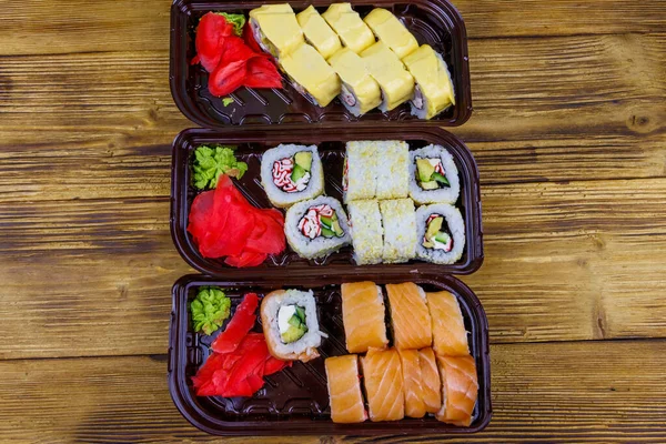 Set Rollos Sushi Cajas Plástico Sobre Mesa Madera Vista Superior —  Fotos de Stock