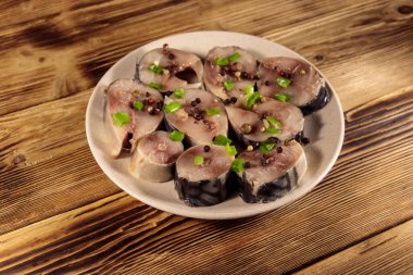 Tahta masada baharatlı dilimlenmiş uskumru. Tabakta tuzlu scomber.