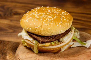 Ahşap masada lezzetli büyük hamburger.