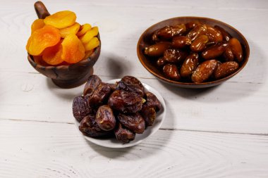 Kurumuş kayısılar ve beyaz ahşap masada meyveler.