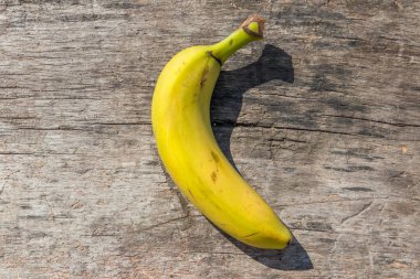 Kırsal ahşap masada lezzetli, olgun, sarı muz meyvesi. Üst görünüm