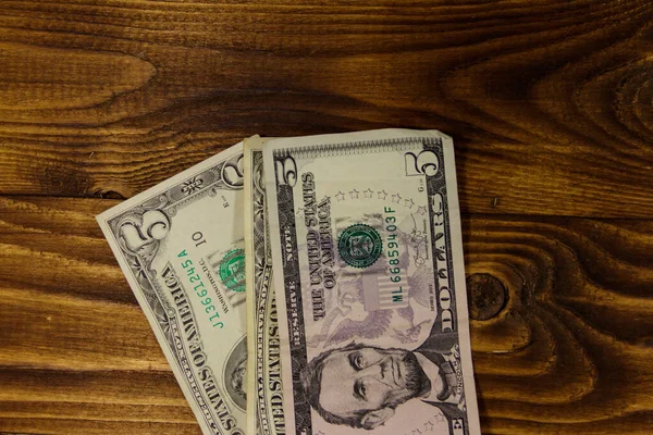 Ahşap arka plan üzerinde beş dolarlık banknot. Üstten görünüm