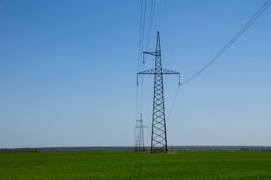 Mavi gökyüzüne karşı yüksek voltajlı güç hattı