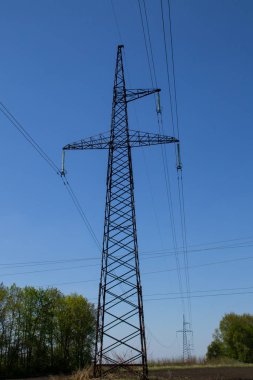 Mavi gökyüzüne karşı yüksek voltajlı güç hattı