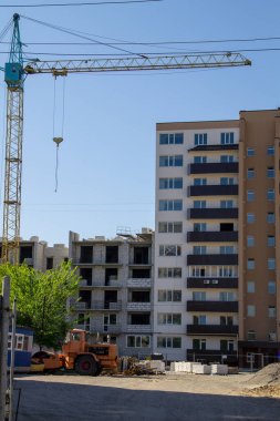 Mavi gökyüzüne karşı inşaat halindeki vinç ve bina