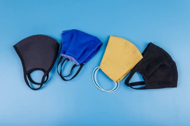 Mavi arka planda yeniden kullanılabilir kumaş maskeler. Üst Manzara. Koronavirüs önleme kavramı