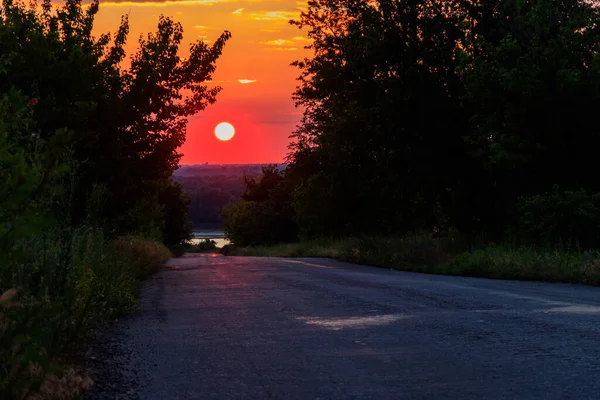 田舎のアスファルトの道路上の美しい夕日 — ストック写真