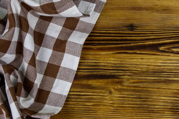 Kahverengi, ahşap mutfak masasında katlanmış peçete. Üst görünüm, alanı kopyala