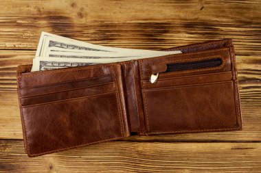 Ahşap masanın üzerinde Amerikan doları olan açık cüzdan. Üstte görüntü