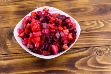 Ahşap masada pancar, havuç, patates, soğan ve salatalık turşusu ile geleneksel Rus salatası vinaigrette