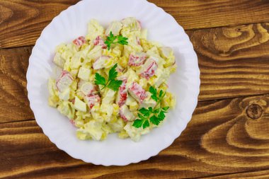 Yengeç saplı salata, tatlı mısır, Çin lahanası, yumurta ve mayonez ahşap masada.