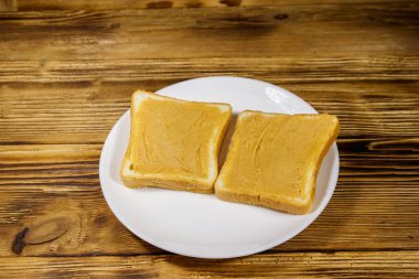 Tahta masada fıstık ezmeli iki dilim ekmek.