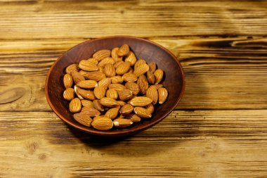 Kırsal bir masada seramik tabakta badem.