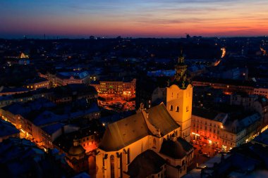 Ukrayna, Lviv 'deki Aydınlatılmış Latin Katedrali ve Rynok Meydanı' nın gece görüşü. Lviv belediye binasından görüntü