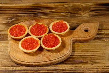 Tahta bir masada kırmızı havyarlı turta.