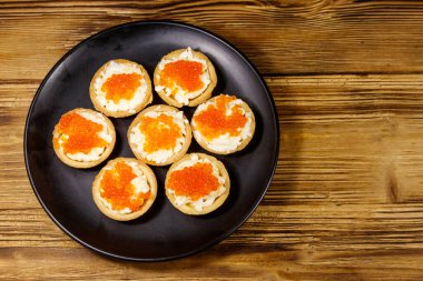 Kırmızı havyarlı turta ve ahşap bir masada yumuşak peynir. Üst görünüm