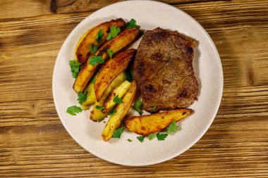 Tahta masada patates dilimli kızarmış biftek. Üst görünüm