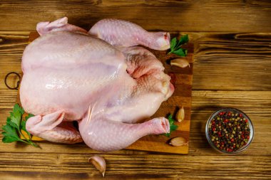 Ahşap bir masada baharatlı bütün bir tavuk. Üst görünüm