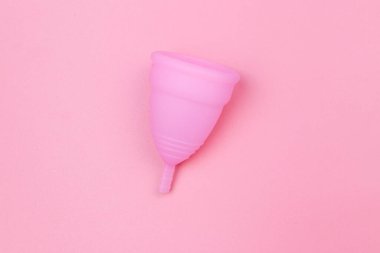 Pembe arka planda tekrar kullanılabilir silikon adet kupası. Üst Manzara. Kadın hijyeni, jinekoloji ve sağlık kavramı