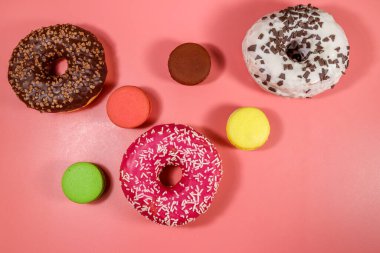 Pembe arka planda lezzetli çörekler ve kurabiyeler. Üst görünüm