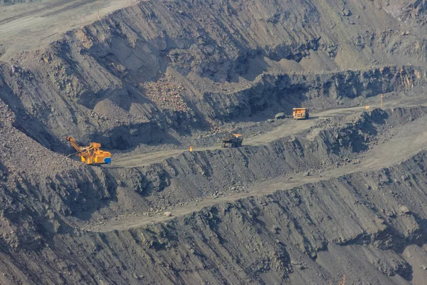 大型铁矿采石场 配有工作倾卸卡车和挖掘机 — 图库照片