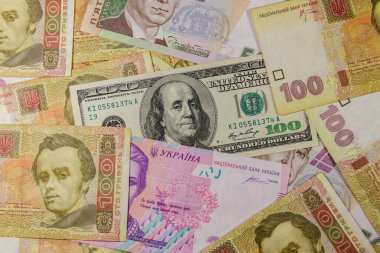 Farklı Ukrayna Hryvnia banknotlarının arka planında 100 dolarlık banknot