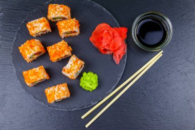 Suşi Philadelphia 'yı siyah bir levhada yuvarlıyor. Üst görünüm