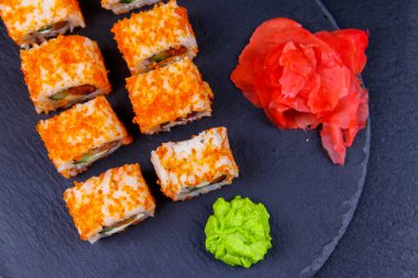 Suşi Philadelphia 'yı siyah bir levhada yuvarlıyor. Üst görünüm