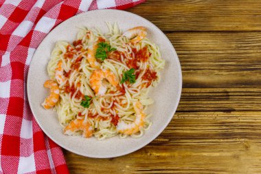 Karidesli spagetti makarna, domates sosu ve ahşap masada maydanoz. Üst görünüm