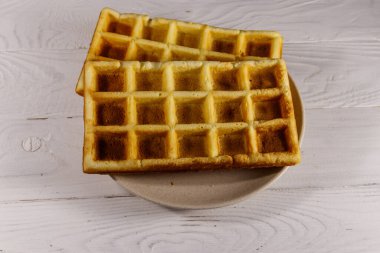 Beyaz ahşap masada Belçika waffleları. Üst görünüm