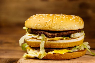 Ahşap masada lezzetli büyük hamburger.
