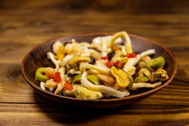 Tahta masada karides, mürekkep balığı ve midye ile deniz ürünleri salatası.