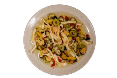 Beyaz arka planda karides, kalamar ve midye içeren deniz ürünleri salatası.