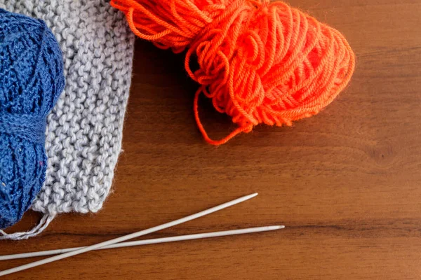 Yünlü iplik, örgü, ahşap masaya örgü iğneleri.