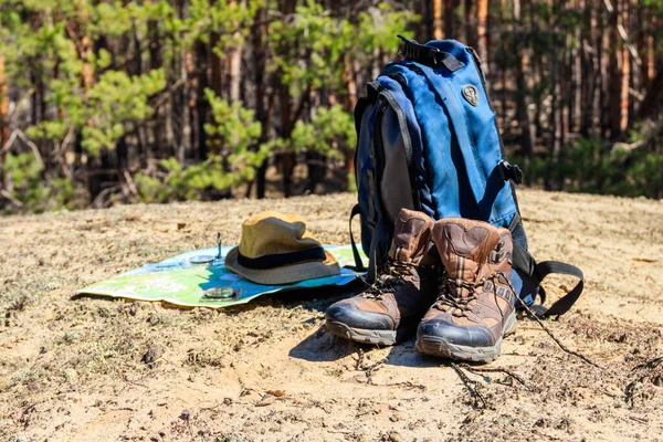 Touristenrucksack Mit Wanderschuhen Hut Kompass Und Karte Auf Der Lichtung — Stockfoto