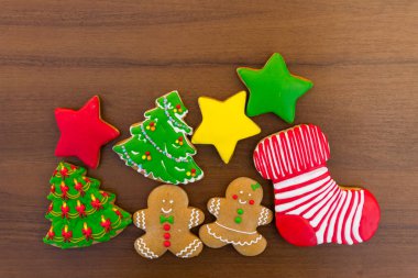 Noel ağacı şeklindeki lezzetli Noel kurabiyeleri, zencefilli kurabiye adam, yıldız ve tahta masadaki Noel çorabı. Üst görünüm