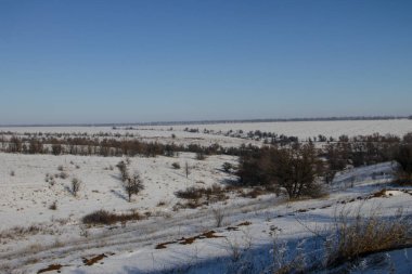 Ağaçlı ve tepeli kış manzarası