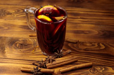 Ahşap masada sıcak şarap ve baharatlar.