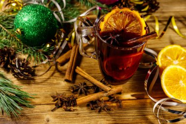 Baharatlı Noel şarabı ve ahşap masada Noel süsü.
